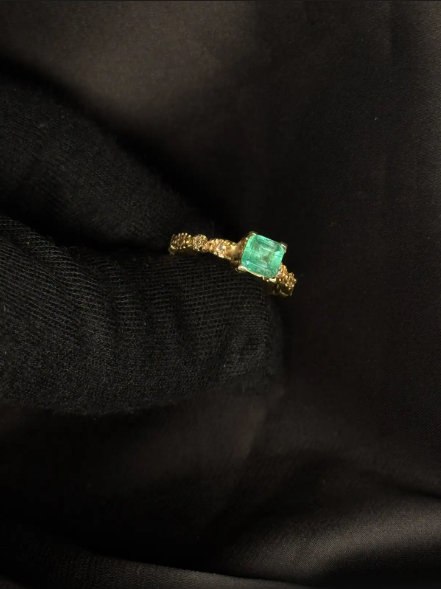 Anillo en oro amarillo 18K con esmeralda en uñas y diamantes